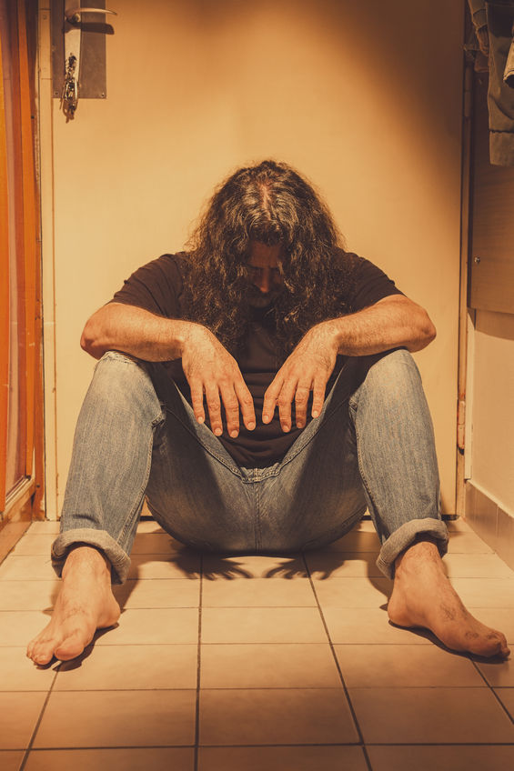 Man sitting on a floor tiles, sad, depressed and lonely